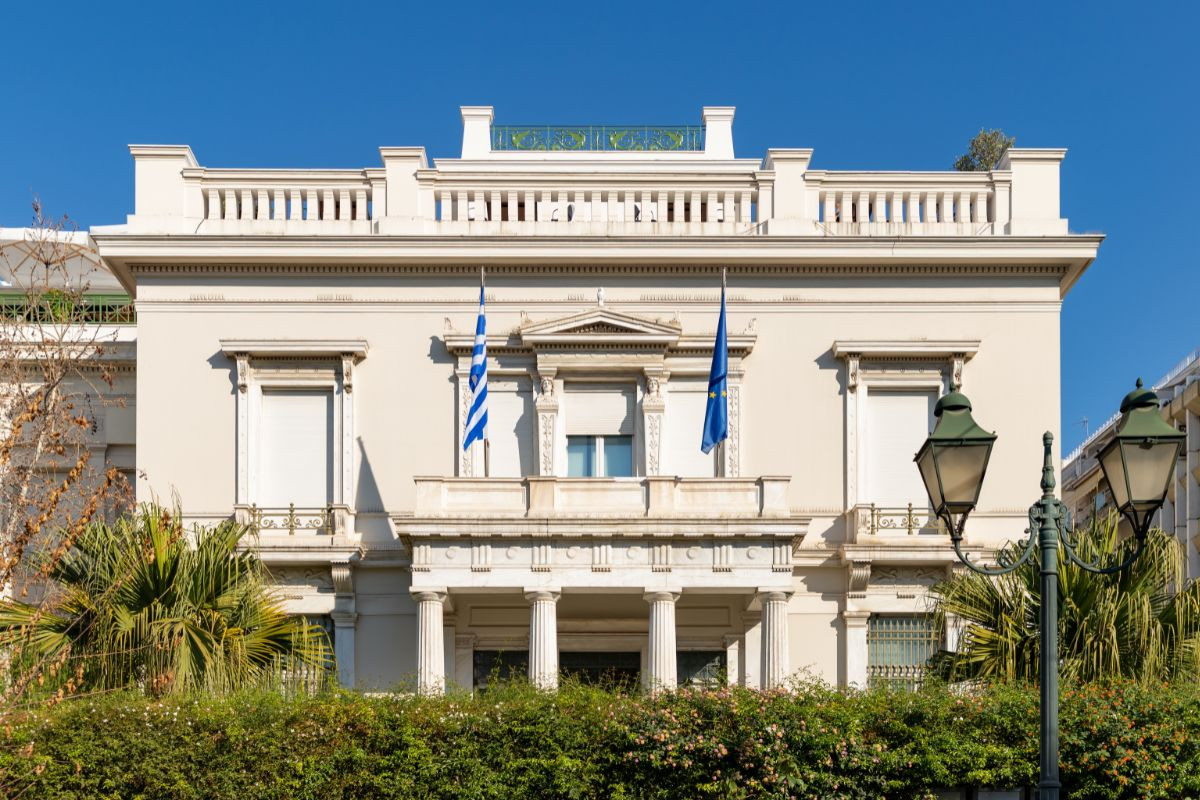 The Benaki Museum in Athens, Greece, a neoclassical building with Greek and European Union flags displayed on its facade.